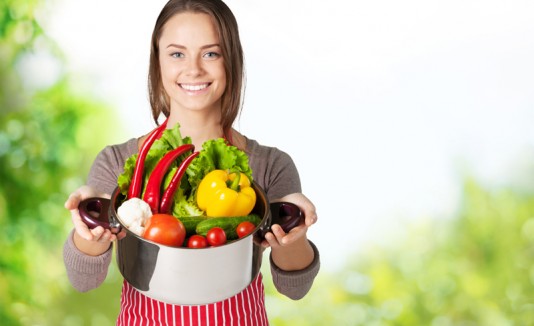 Mujer con frutas y vegetales en una olla
