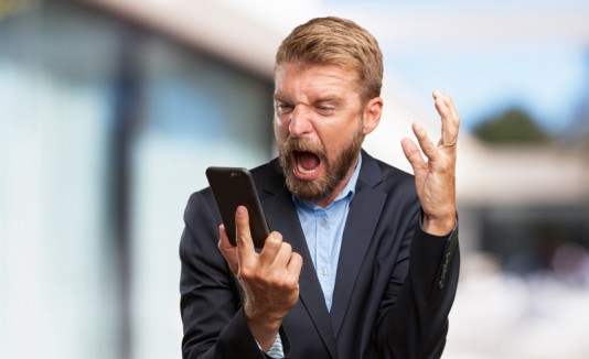 Hombre con celular gritando