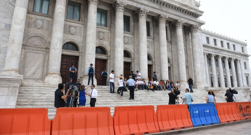 Ciudadanos y manifestantes se sentaron en las escalinatas del Capitolio luego de que se les impidiera en acceso a las gradas de la Cámara de Representantes, donde se discute el proyecto que elimina la Comisión de Auditoria Integral del Crédito Público.